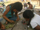 Niñas y niños jugando con flores y barro